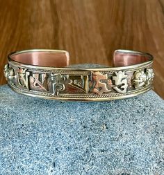 This beautiful Tibetan cuff bracelet is made in Nepal. Size: 18cm - As It's open-ended, would fit most hands Width - 13mm approx Weight - 23 gms approx Material: white metal, copper, brass To fit the bracelet open it up so the gap is wide enough to pass over the narrowest part of your wrist and then squeeze it back into shape until it is a nice comfortable fit. Please note due to this item being handmade there may be some imperfection. Buddhist Bracelet, Om Mani Padme Hum, Twist Ring, Open Ended, Copper And Brass, Bracelet Bangle, Spiritual Jewelry, Silver Cuff Bracelet, Silver Cuff