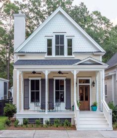 a white house with gray shutters on the front porch