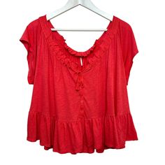 Free People Charlie Top Ruffled Relaxed Short Sleeve Blouse. Scoop neck with self tie and button down front. Crochet lace details. Flounce ruffle hem, almost like a peplum. Soft and flowy material. Color is called pink but it is like a red, pink, and orange color combo. Short sleeve t-shirt with a slightly cropped and boxy fit. Women's size medium Rayon and linen blend Approximate measurements with the garment laying flat: Pit to pit: about 24 inches Length: about 18 inches Summer Tie Neck Blouse With Ruffles, Summer Peplum Top With Ruffles For Daywear, Spring Peplum Top With Lace Trim, Flowy Tie Neck Top For Summer, Casual Summer Peasant Top With Ruffle Hem, Casual Short Sleeve Peasant Top With Ruffles, Casual Peasant Top With Ruffles And Short Sleeves, Casual Ruffled Peasant Top For Daywear, Bohemian Short Sleeve Top With Ruffle Hem