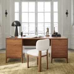 a wooden desk topped with a white chair next to a window