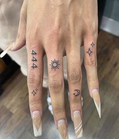 a woman's hand with tattoos on her fingers and the number 544 written in black ink