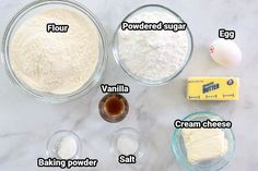 ingredients to make an egg cake laid out on a marble counter top, including flour, butter, sugar and eggs