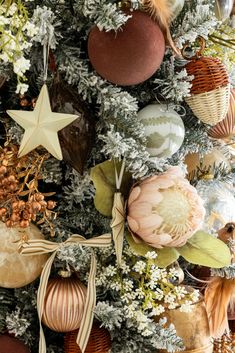 a christmas tree with ornaments hanging from it's branches and decorations on the top