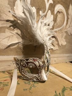 "This mask with feathers belongs to our collection of masks \"Lady Plumes\". The fetaher masks are the most elegant, refine and stunning masks of our collections. This mask is a traditional and original papier-mache Venetian mask, handmade and decorated in our Atelier in Venice using velvet , fabrics, Swarovski, feathers, different trimming. It is perfect for any masquerade party, Halloween costume, pro or event in Venice or elsewhere during Carnival. This mask can be gently bent to form to your Fantasy Full Face Mask For Carnival, Fantasy Full Face Costume Mask, Full Face Fantasy Costume Mask, White Fantasy Eye Mask, Vintage Masks For Mardi Gras Costume Party, Venetian Eye Mask For Costume Party, Vintage Eye Mask For Costume Party, Fantasy Style Costume Eye Mask, Venetian Mask For Mardi Gras Costume