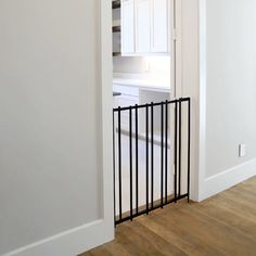 an open door leading to a kitchen with white cabinets