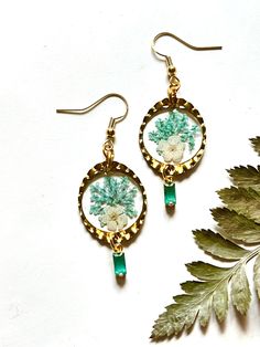 This lightweight pair of earrings was made using real flowers, leaves, and resin.  Accented with faceted glass charms Gold components and nickel free earring hooks. Bohemian Dangle Earrings With Pressed Flowers, Bohemian Drop Earrings With Pressed Flowers, Unique Flower-shaped Resin Earrings, Bohemian Dangle Jewelry With Pressed Flowers, Bohemian Flower Earrings With Pressed Flowers, Bohemian Pressed Flowers Drop Earrings, Bohemian Pressed Flower Earrings, Bohemian Dangle Earrings With Birth Flower, Nature-inspired Dangle Earrings With Pressed Flowers