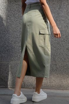 Contemporary style meets its match with this cargo maxi skirt from Threadbare. Cut in a slim fit, this maxi cotton cargo skirt has a zip fly with a metal shank button fastening and the waistband is finished with belt loops. There are two pockets to the front with a small coin pocket, with added patch cargo pockets on the sides have pleats. Pair with flats and a black or ecru crochet knitted top for a super stylish outfit that's on trend, or take into the evening with a bodysuit, strappy heels and a blazer. Model Wears UK Size 8. Cargo Skirts Long, Green Cargo Skirt Outfits, Maxi Cargo Skirt, Cargo Skirt Outfit, Skirt Cargo, Cargo Outfit, Holiday Outfits Women, Cotton Maxi Skirts, Womens Khakis