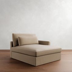 a couch sitting on top of a hard wood floor next to a white wall in an empty room