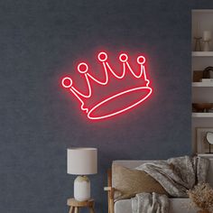 a neon sign with a crown on it in a living room next to a couch