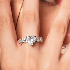 a close up of a person's hand with a diamond ring on their finger