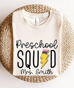 Show off your preschool pride with our Preschool Teacher Shirt. This retro-inspired tee is perfect for back to school, teacher appreciation, or any day you want to celebrate your role as a preschool educator. Join the Preschool Squad and make a stylish statement in the classroom! Product Description: ⇝ Bella and Canvas Brand Shirts ⇝ Unisex Adult Sizing ⇝ Rolled Sleeves in pictures are for styling purposes only ⇝ Props used in photos for are NOT included with purchase ⇝ Please consult the listin Preschool Teacher Tshirts, Back To School T-shirt With Heat Transfer Vinyl, Preschool Director Outfits, Customizable Crew Neck School T-shirt, White School Spirit T-shirt, Customizable T-shirt For Back To School Events, Customizable School Spirit Tops For School, Back To School Spirit T-shirt With Name Print, White School Spirit T-shirt For Back To School