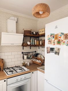 a kitchen with white appliances and wooden counter tops next to a wallpapered backsplash