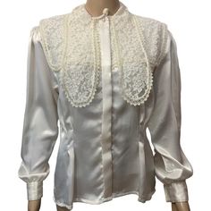 "Vintage 1970's long sleeve high neck blouse. Satiny feel blouse is very feminine with pearl buttons and lace accents . Lightly padded shoulders with pleats down to slightly puffed sleeves with double pearl button cuffs. Fitted at the waist with a covered button front.  A square lace panel accents the back. The front is accented with unique layered lace panels . Wear it buttoned up or unbutton and layer with a lace cami or bustier.  100% polyester  Made in Taiwan Size 8  Measures Approximately Boho Beauty, High Neck Blouse, Bohemian Blouses, Lace Cami, Pearl Buttons, Vintage Bohemian, Victorian Style, Blouse Styles, Victorian Fashion