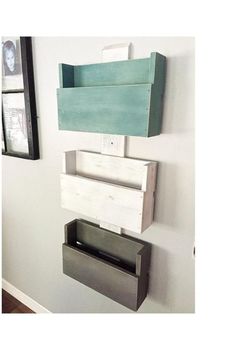 a wall mounted shelf that has some boxes on top of it and a mirror above it