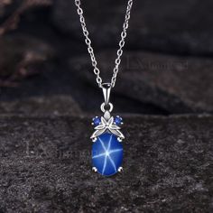 Item description ✦ Handmade, high-quality item! ✦ Material: 925 sterling silver, Solid 14K/18K GOLD (can be made in white/rose/yellow gold), Platinum ✦ Center Stone: 7x9mm Oval Cut Lab Blue Star Sapphire ✦ Side Stones: Round Cut Lab Blue Sapphires ✦ Chain length can be adjusted between 16 inches and 18 inches As it is handmade, it needs 2-4 weeks to finish and then be shipped by USPS or FedEx. Return policy: We offer 30 days return policy. For any reason, if you are not completely satisfied with Celestial Hallmarked Jewelry With Oval Stones, Celestial Style Hallmarked Oval Jewelry, Silver Celestial Jewelry With Oval Cabochon, Blue Oval Pendant Necklace For Anniversary, Celestial Blue Birthstone Necklace, Silver Oval Celestial Necklace, Blue Sapphire Jewelry In Oval Cabochon Shape, Celestial Silver Oval Necklace, Oval Sapphire Necklace With Hallmark