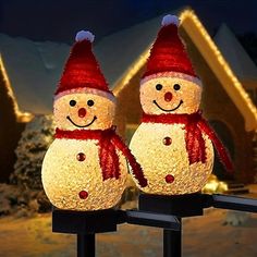 two lighted snowmen standing next to each other