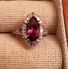 This beautiful ring is a perfect addition to any jewelry collection. Crafted with natural rhodolite garnet in a marquise shape, this ring features a stunning 6mm wide and 12mm long main stone, which is set in rose gold metal. The ring is also adorned with a secondary diamond stones, adding to its elegance. The ring is size 5.5 and can be resized if needed. It is a perfect gift for someone special or can be worn to add a touch of sophistication to any outfit. Don't miss the chance to own this uni