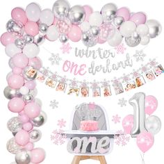 a pink and silver first birthday party with balloons, cake and decorations for one year old