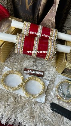 two pairs of red and gold bangles sitting on top of a white fur rug