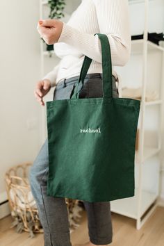 Our Essential custom name embroidered tote bag is made to order and personalized with your name on it! This tote bag is the perfect size to carry all of your daily essentials, making it perfect as a casual everyday bag or a reusable grocery tote. Perfect for yourself, mom, bridesmaids, teachers, Christmas or Bday gift! DETAILS - 100% cotton - Natural (15 1/2 in x 16 in) - Black (16 1/2 in x17 1/2 in) - Machine Embroidered HOW TO ORDER 1) From the dropdown menu, choose your tote bag color 2) In t Personalized Green Bags For Daily Use, Customizable Green Bags For Daily Use, Green Embroidered School Bag, Green Bag With Embroidered Logo For Everyday Use, Customizable Green Bags For Personalized Gifts, Green Cotton Canvas Bag For Gift, Personalized Rectangular Cotton Bags, Eco-friendly Embroidered Canvas Bag As Gift, Embroidered Cotton Canvas Bag For Gift