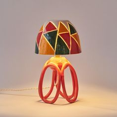 a lamp that is sitting on top of a table next to a corded light