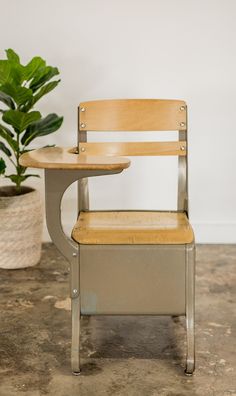 a chair with a table on it next to a potted plant