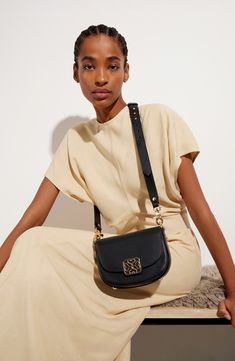 It's debuts all around for the Bay bag—a new collection that leans into the brand's equestrian and artisinal traditions with its saddle silhouette. A new brand-monogram logo fronts the flap on this mini crossbody crafted from smooth calfskin leather. Magnetic flap closure Removable, adjustable crossbody strap Interior wall pocket Protective metal feet Textile lining Leather Made in Spain Designer Handbags Bag Clasp, Saddle Crossbody Bag, Leather Detailing, Fabric Gift Bags, Interior Wall, Mini Crossbody, Monogram Logo, Black Cross Body Bag, Crossbody Strap