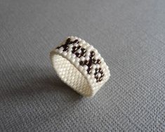 a white beaded ring sitting on top of a table