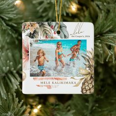 an ornament hanging from a christmas tree with two children playing in the water