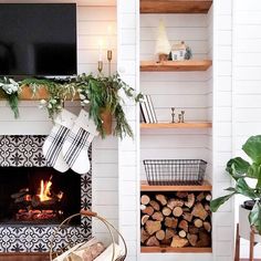 a living room filled with furniture and a fire place in front of a tv mounted on a wall