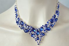 "This beautiful, dramatic vintage inspired fancy cut crystal rhinestone necklace and earrings set features fancy cut pear and round brilliant cut sapphire blue crystal rhinestones set in silver plated settings. There is a mixture of pear cut sizes for a dramatic look. It is shown with a chain and clasp closure but it can also be made with a ribbon closure if you prefer. This set is perfect for someone looking for a dramatic look. The earrings are included for free. Really beautiful quality and amazing sparkle! For pierced ears. Measurements: Necklace: Tied to desired length with ribbon of your choice or chain & clasp Drop:  1-1/2\" L Earrings: 2\" L x 1/2\" W Your choice of closure (ribbon or chain/clasp) from the pull-down menu. I have many colours of ribbon if you don't see what you want Special Occasion Jewelry, Rhinestone Statement Necklace, White Jewelry Box, Sparkle Wedding, Necklace And Earrings Set, Jewelry Card, Necklace And Earring Set, Wedding Jewelry Sets, Sapphire Blue