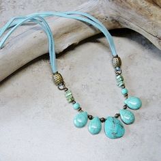 "Rustic southwestern styling in this beaded faux suede aqua cord necklace. Antique brass beads accent tear drop turquoise blue magnesite beads. The focal beaded segment is linked to soft faux suede aqua blue ties that are accented with antique brass beads and links and crimped to a matching lobster claw closure. Length of the necklace is 24\" All of my jewelry items come boxed and lace ribbon tied and tagged for easy gifting. This necklace is ready to ship." Bohemian Turquoise Necklace With Adjustable Cord, Adjustable Turquoise Necklace With Cord, Artisan Turquoise Necklace With Adjustable Cord, Turquoise Necklace With Adjustable Cord, Southwestern Style Adjustable Teardrop Necklace, Adjustable Bohemian Turquoise Necklace With Round Beads, Bohemian Adjustable Turquoise Necklace With Round Beads, Adjustable Beaded Necklace With Teardrop Pendant, Handmade Bohemian Teardrop Turquoise Necklace