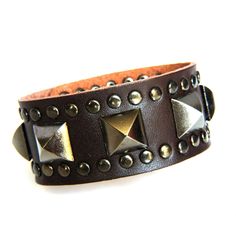 Genuine Leather Vintage style Bracelet that is Super Sexy This bracelet is designed with a 9 1/2 inch length piece of Brown genuine cowhide leather (1 1/4 inch wide) that is given Sexy Style with a center row of Antiqued Gray Pyramid Studs and a border of Rivet Studs.  It is finished with (2) sets of matching snaps for a wearable size variation of 7 1/2" & 8 1/4" Check out the rest of our Bling Collection at our eBay Store...The Lionz Bling. Thick Leather Bracelet, Brown Leather Punk Style Jewelry, Punk Style Brown Leather Jewelry, Edgy Leather Bracelets With Rivets, Adjustable Brown Punk Bracelets, Brown Punk Leather Bracelet For Gift, Adjustable Leather Wristband With Rivets, Edgy Leather Cuff Bracelet, Trendy Brown Rectangular Bracelet