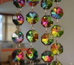 the sunlight is hanging from a chain with many different colored jewels on it's sides