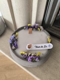 there is a cake with flowers on it and a name plate that says heart de lis