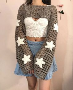 a woman wearing a crop top with crochet stars on the sleeves and bottom