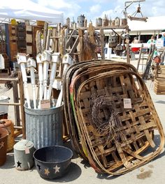 an assortment of wooden utensils and buckets on the ground at a flea market