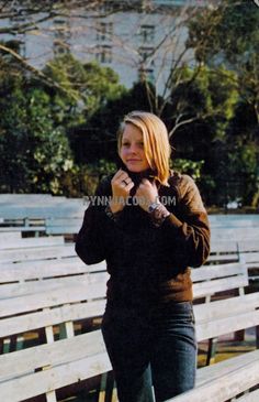 a woman standing in front of rows of wooden benches