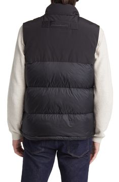 Weather it all in comfort and warmth wearing this vest featuring dual-entry pockets, a webbing grab strap at the upper back and 625-fill-power down insulation. 28" length (size Medium) Storm placket Stand collar Durable water-repellent (DWR) finish Lined, with 625-fill-power down 100% polyamide with 84% polyester, 16% cotton contrast Dry clean Made in Canada Black Vest For Hiking In Fall, Functional Black Vest Outerwear, Functional Black Outerwear Vest, Black Hiking Vest Outerwear, Sleeveless Down Puffer Vest, Black Sleeveless Vest With Functional Pockets, Winter Utility Nylon Vest, Black Utility Vest For Winter, Black Nylon Outerwear With Functional Pockets