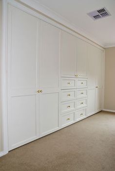 an empty room with white closets and beige carpeted flooring is pictured in this image