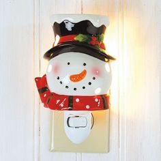 a light that is on the wall with a snowman hat and scarf around it