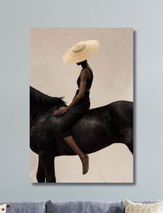 a woman sitting on top of a horse wearing a straw hat and black dress with her legs crossed