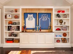 a living room filled with lots of furniture and bookshelves covered in sports memorabilia