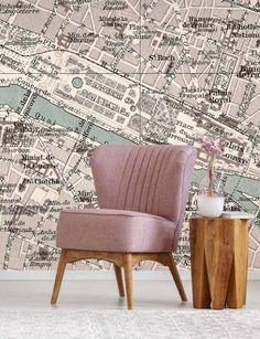 a pink chair sitting in front of a wall with a map on it's side