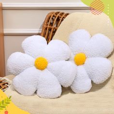 two white flowers sitting on top of a chair