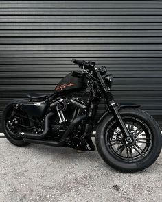 a black motorcycle parked in front of a garage door