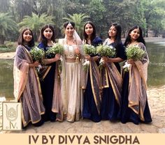 a group of women standing next to each other in front of a body of water