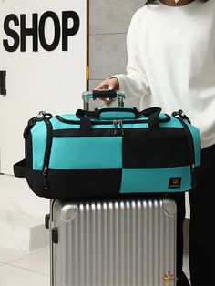 a person holding a blue and black suitcase