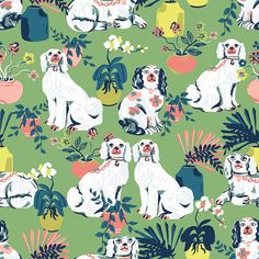 two white dogs sitting next to each other on a green background with flowers and plants