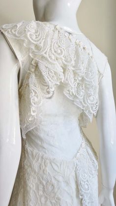 For Sale on 1stDibs - A gorgeous dress from Nina Ricci in white lace. From the front it is a simple V neck sleeveless A line dress in white lace. The back cut out from below Sleeveless Lace Dress With Fitted Bodice, Fitted Sleeveless Lace Bodice Dress, Fitted Sleeveless Lace Dress, Sleeveless White Scalloped Lace, White Scalloped Lace Sleeveless, Sleeveless Lace Dress With Fitted Bodice And Lace Trim, Fitted Sleeveless Lace Dress With Delicate Lace, Feminine Sleeveless Lace Dress With Fitted Bodice, White Sleeveless Lace Dress With Scalloped Lace